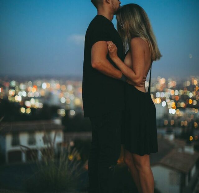 man hugging woman on top of hill during nighttime